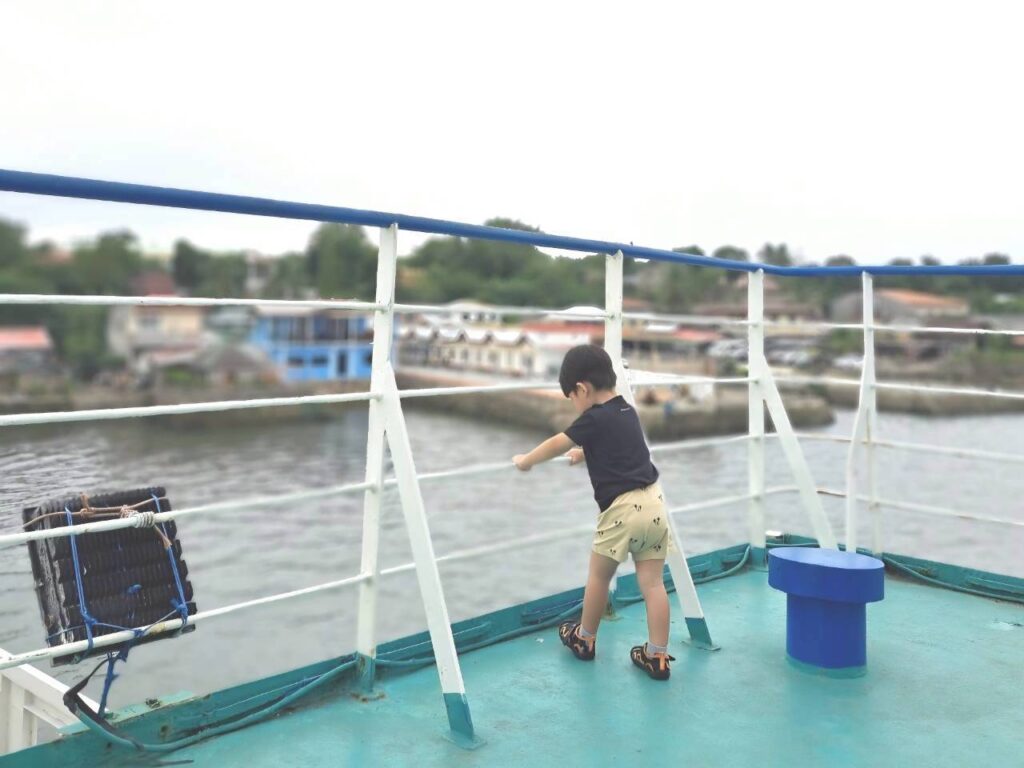 フィリピン　セブ　フェリーに乗り込み、甲板から出港した港を見渡す2歳の男の子